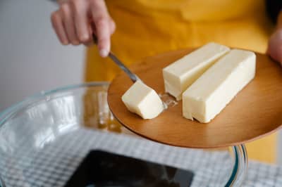 A block of butter with a knife on a chopping board