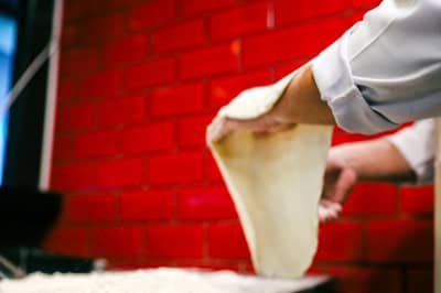 Wet bread dough being stretched and folded over itself